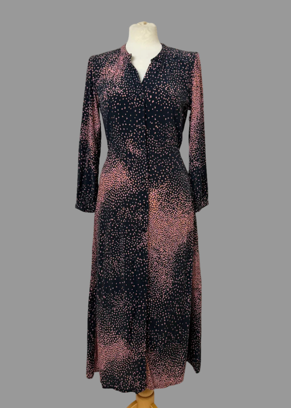Long-sleeve dress with a pattern on a mannequin against a white wall.